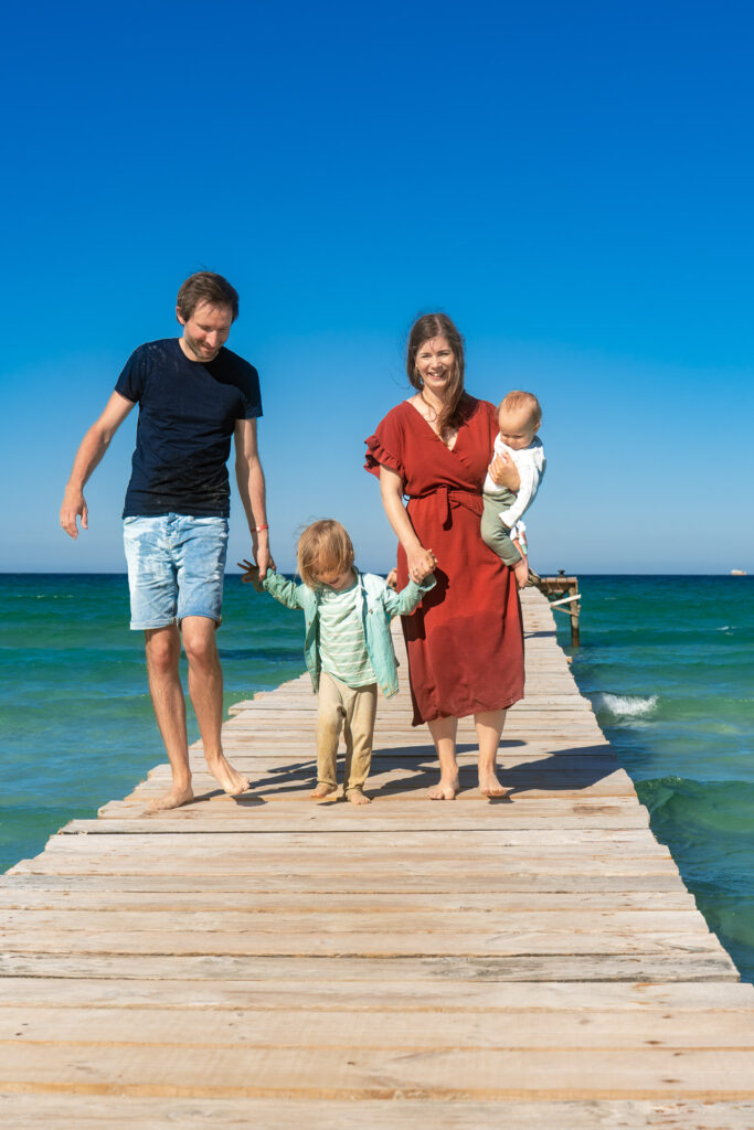 Familie läuft auf dem Holzsteg in Alcudia