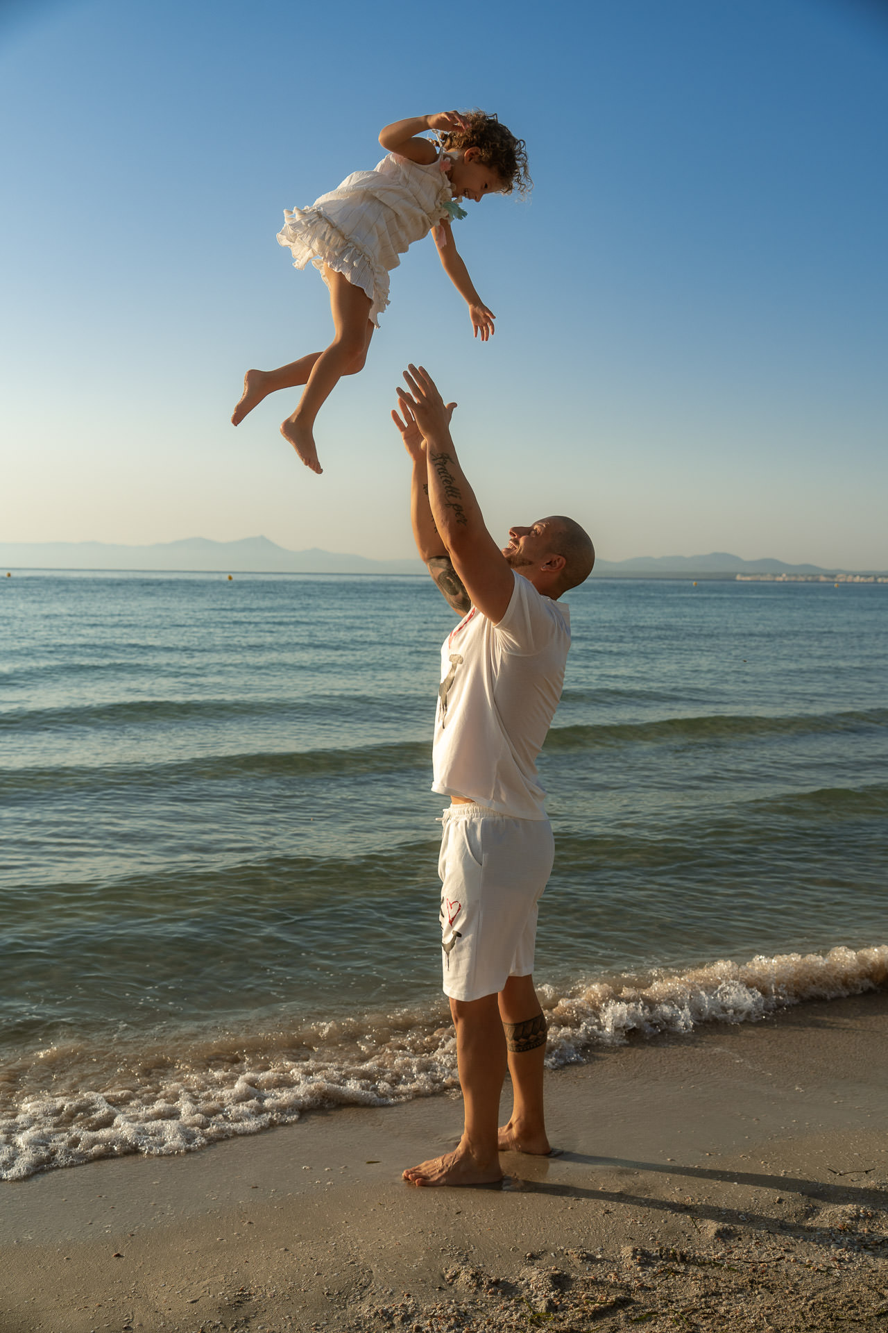 Papa wirft Tochter am Meer in die Luft