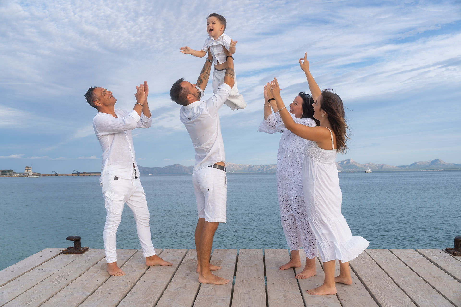 Familie in weißem Outfit auf dem Holzsteg in Alcudia