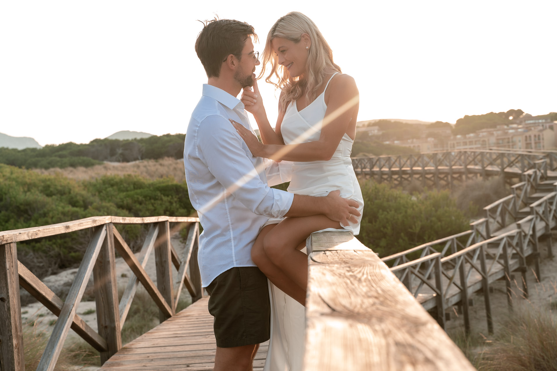 Cala Mesquida Fotoshooting – Eltern mit Tochter auf Holzsteg, Familienglück in den Dünen von Mallorca.