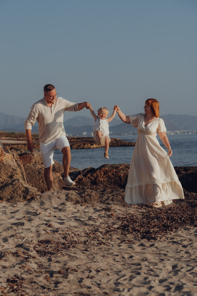 Junge Familie spielt mit Kind Engelchen Flieg an Strand von Can Picafort