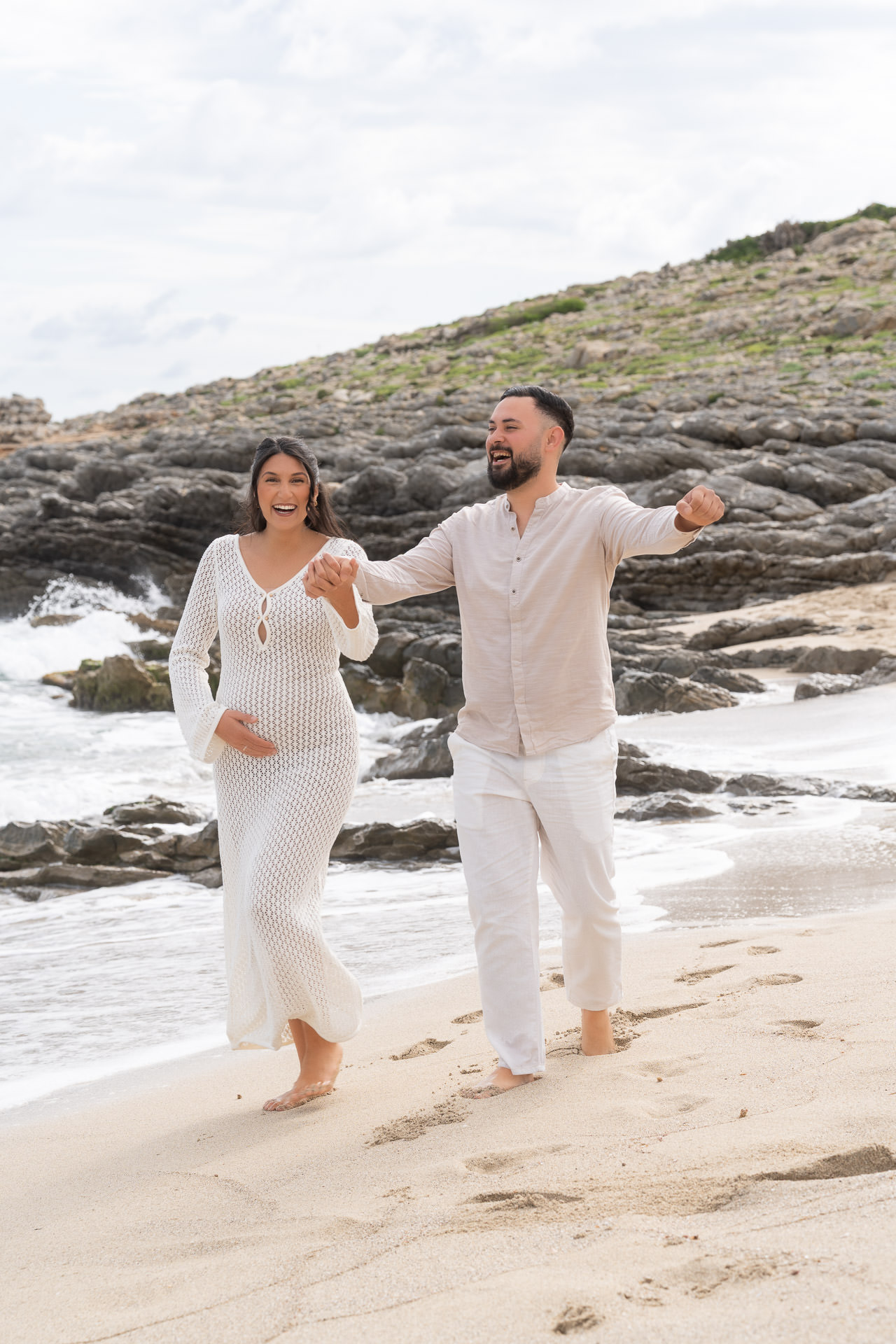Junges Paar am Strand glücklich über die Schwangerschaft