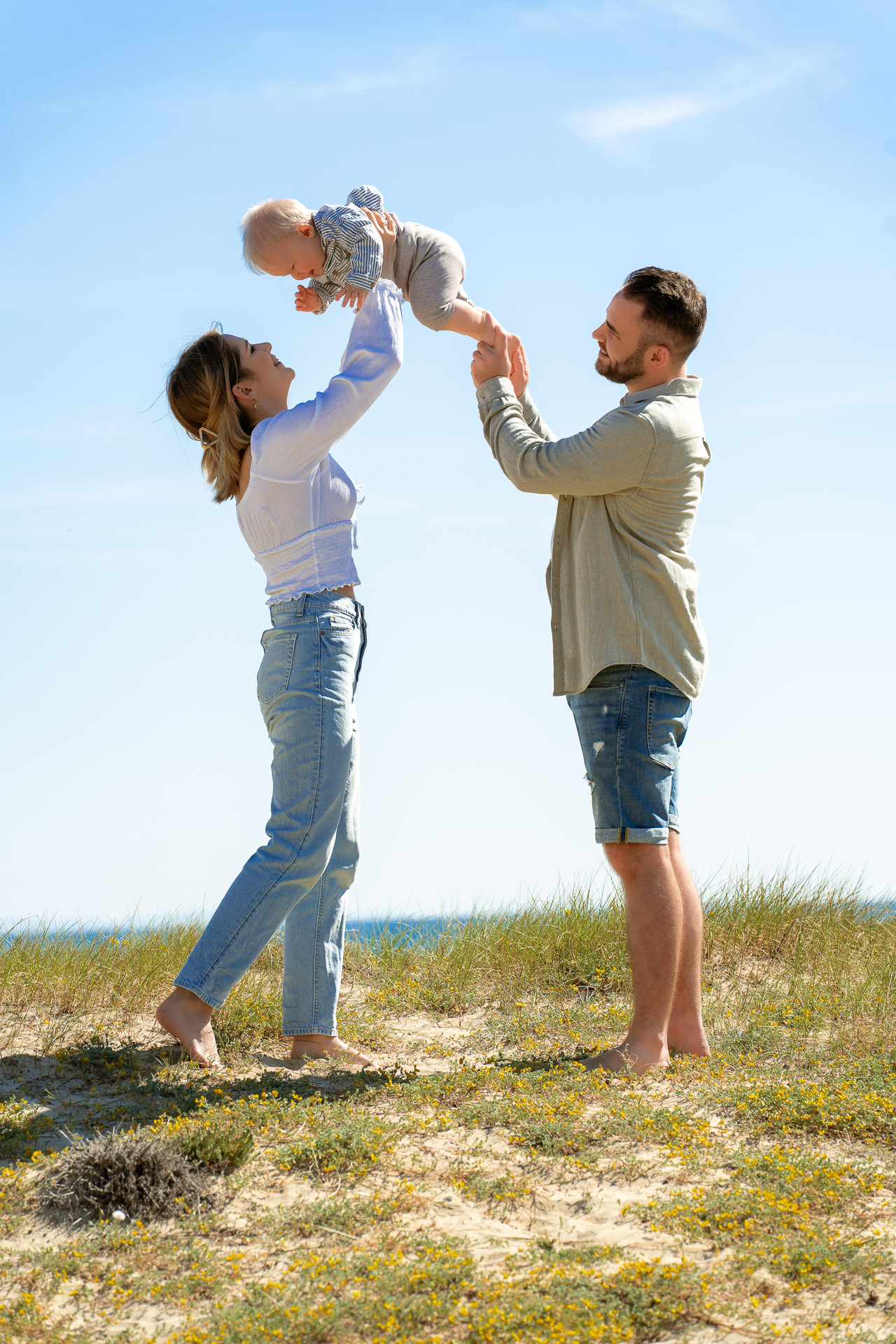 Mutter und Vater heben Baby in die Luft beim Mallorca Familien Shooting