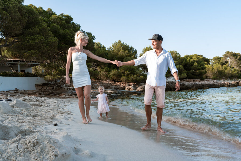 Junges Paar mit kleinem Kind am Strand von Cala Rajada