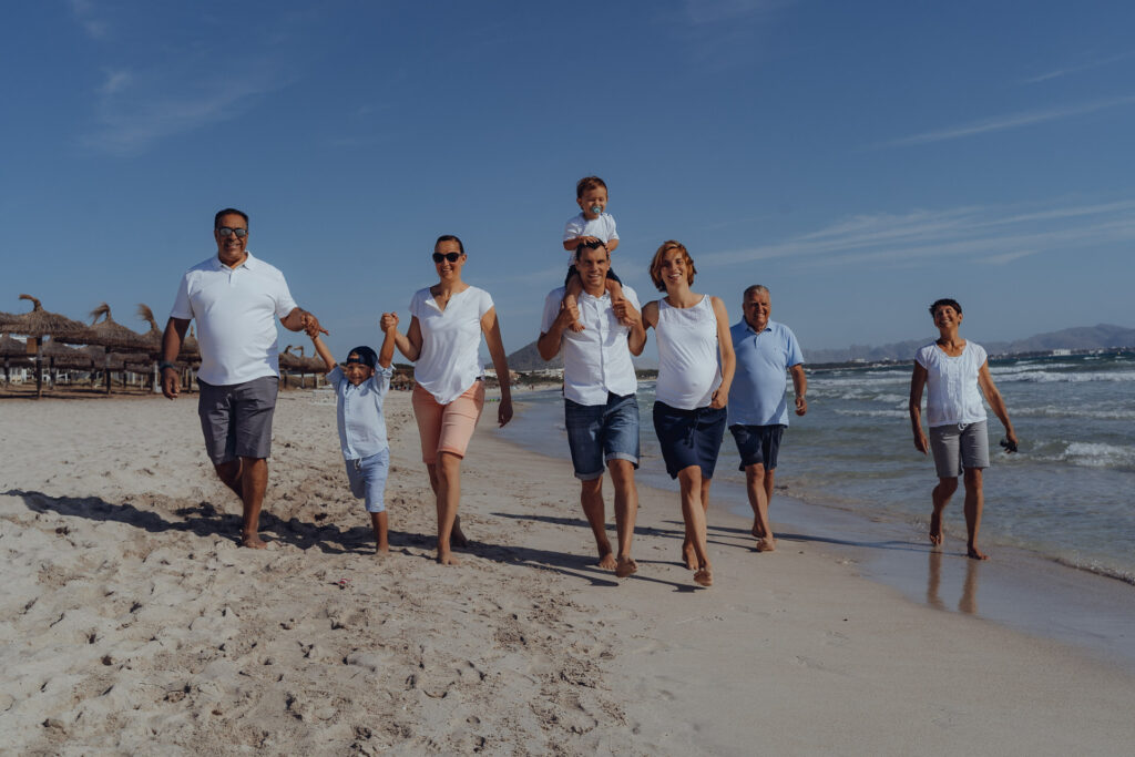 Großfamilie läuft beim Fotoshooting an der Playa de Muro