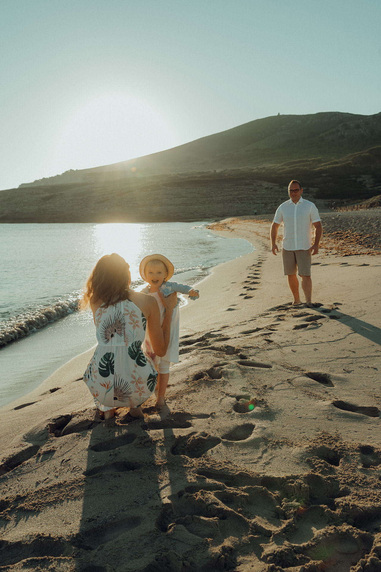 Mallorca Urlaubs Shooting Früh morgens am Strand von Mallorca – Familie genießt den Sonnenaufgang beim Fotoshooting. Mallorca Fotograf für echte Momente im ersten Licht des Tages.