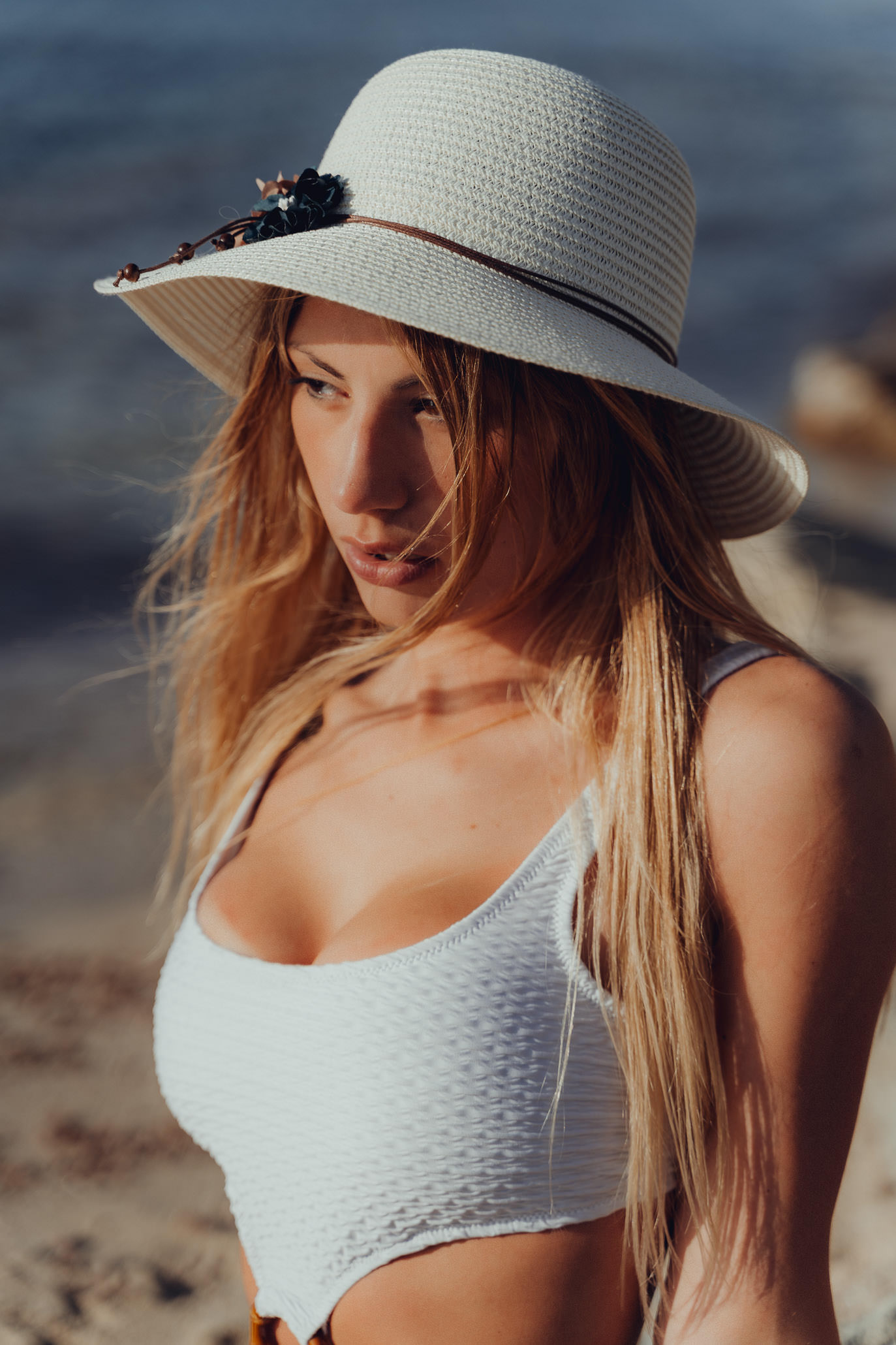 Mallorca Model Shooting Model mit weißem Hut posiert für ein Portrait Bild am Strand