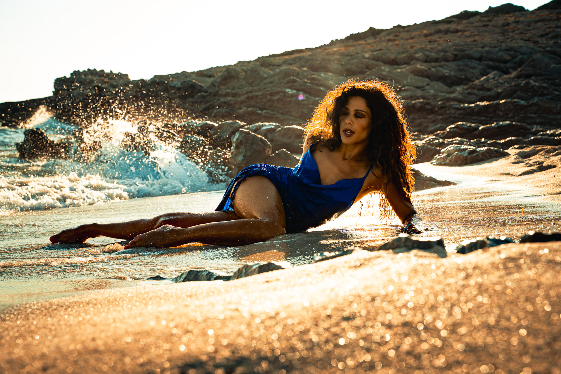 Mallorca Sonnenaufgang Shooting Model liegt am Strand der Cala Mesquida und im Hintergrund geht die Sonnen auf