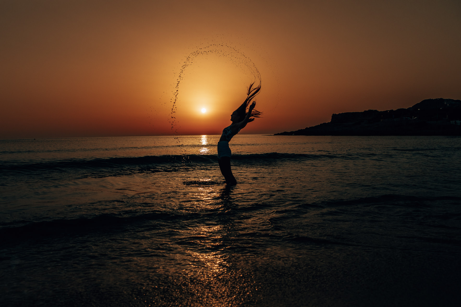 Mallorca Sonnenaufgang Shooting Sonnenaufgang in Cala Rajada und ein Model steht im Meer