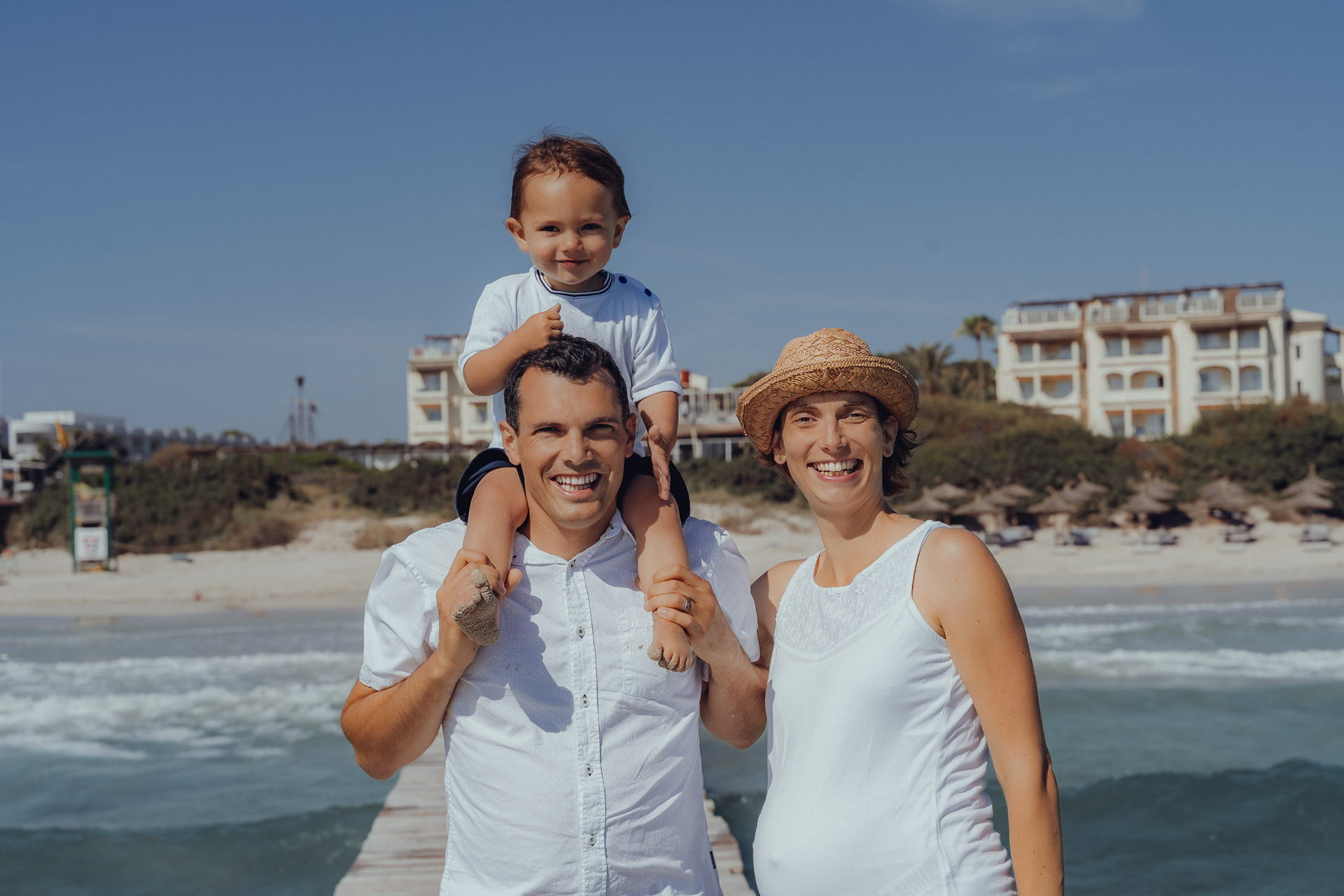 Playa de Muro Fotoshooting Familie mit Kind auf der Schulter des Mannes lächelt in die Kamera