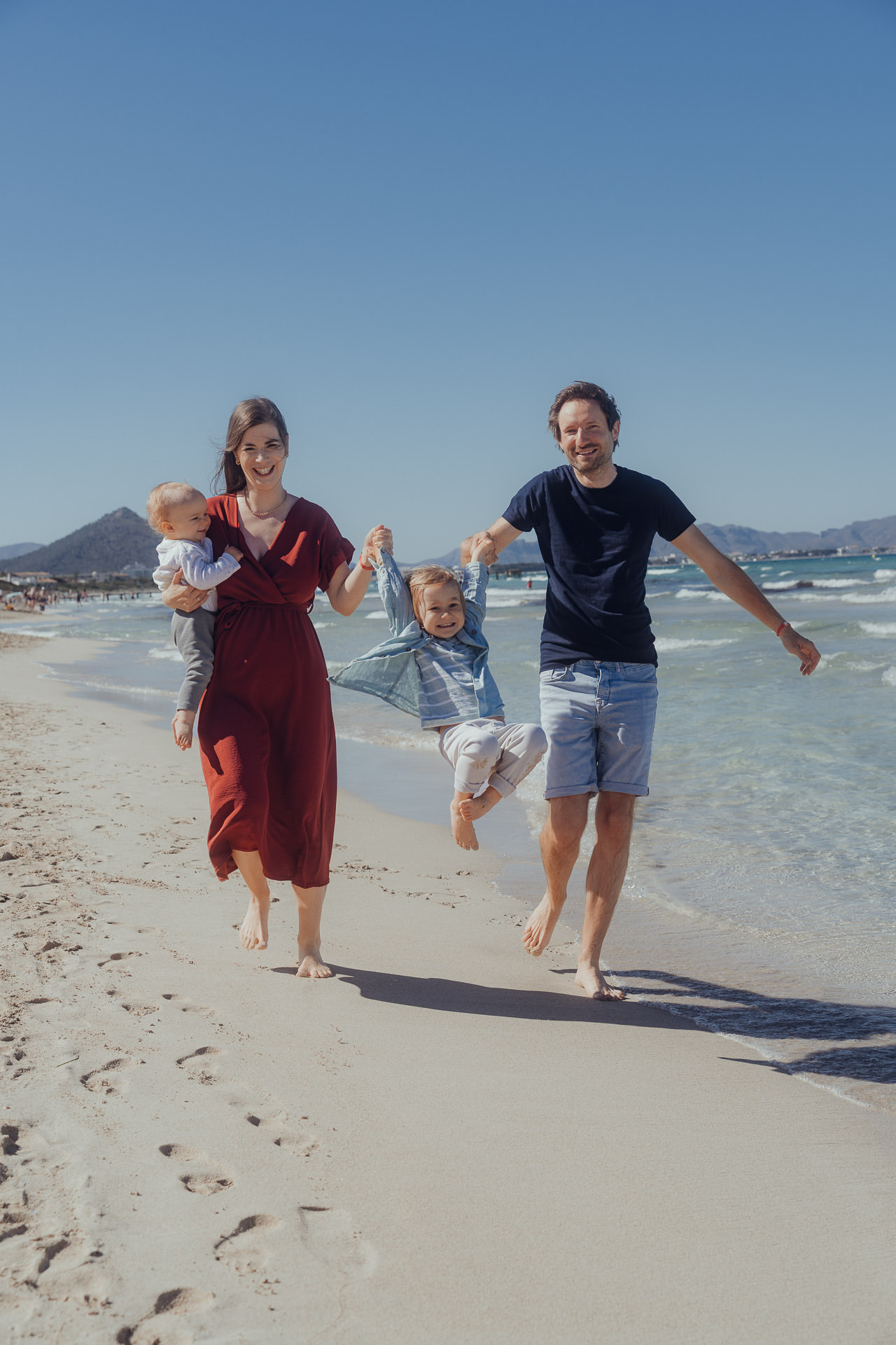 Playa de Muro Fotoshooting Familie spielt Engelchen flieg mit der Tochter am Strand der Playa de Muro