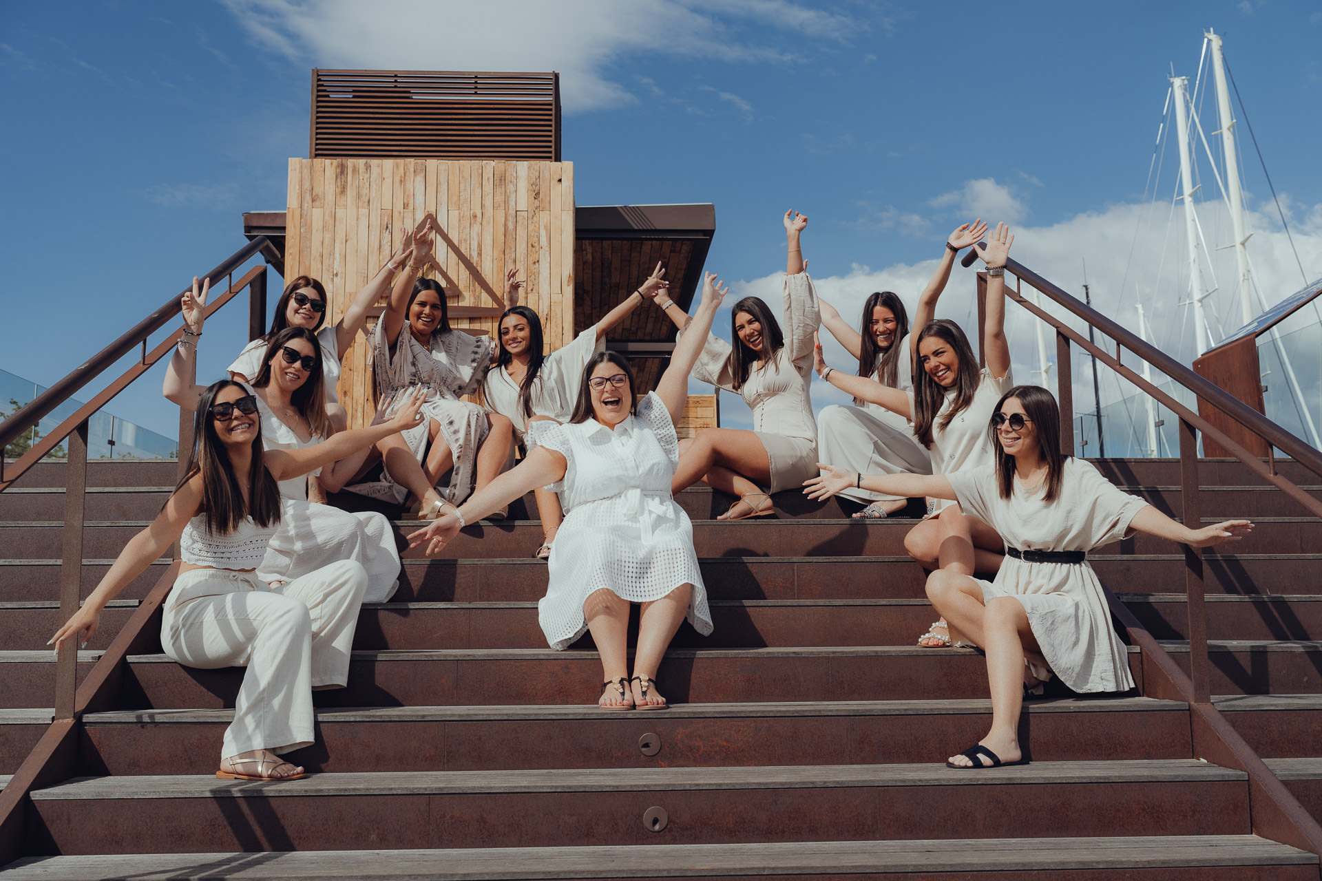 Junggesellinnenabschied auf einer Treppe am Hafen von Palma, alle lachen und jubeln.
