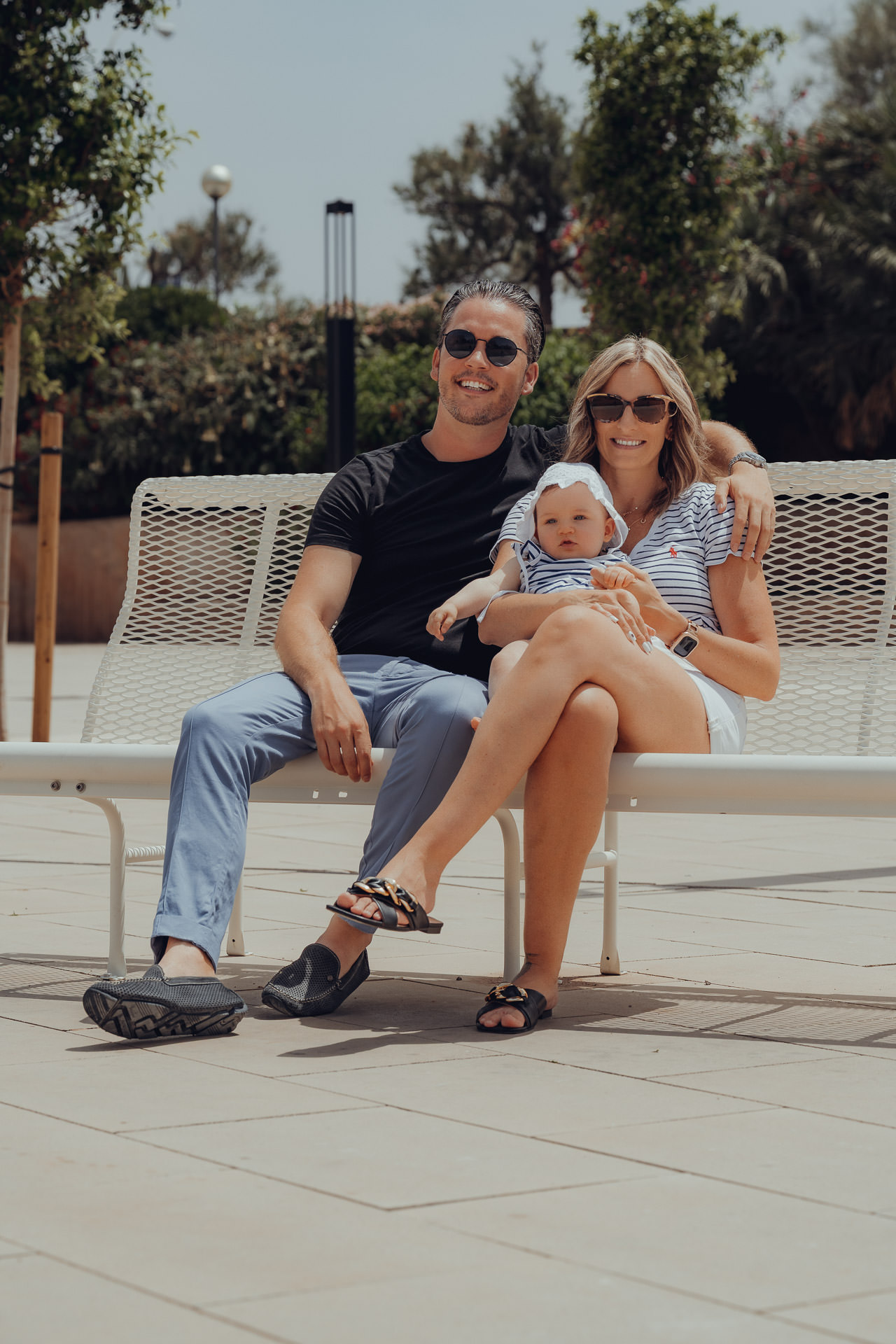 Palma Fotoshooting: Familie entspannt auf einer Bank in der Sonne, modernes Stadtshooting auf Mallorca
