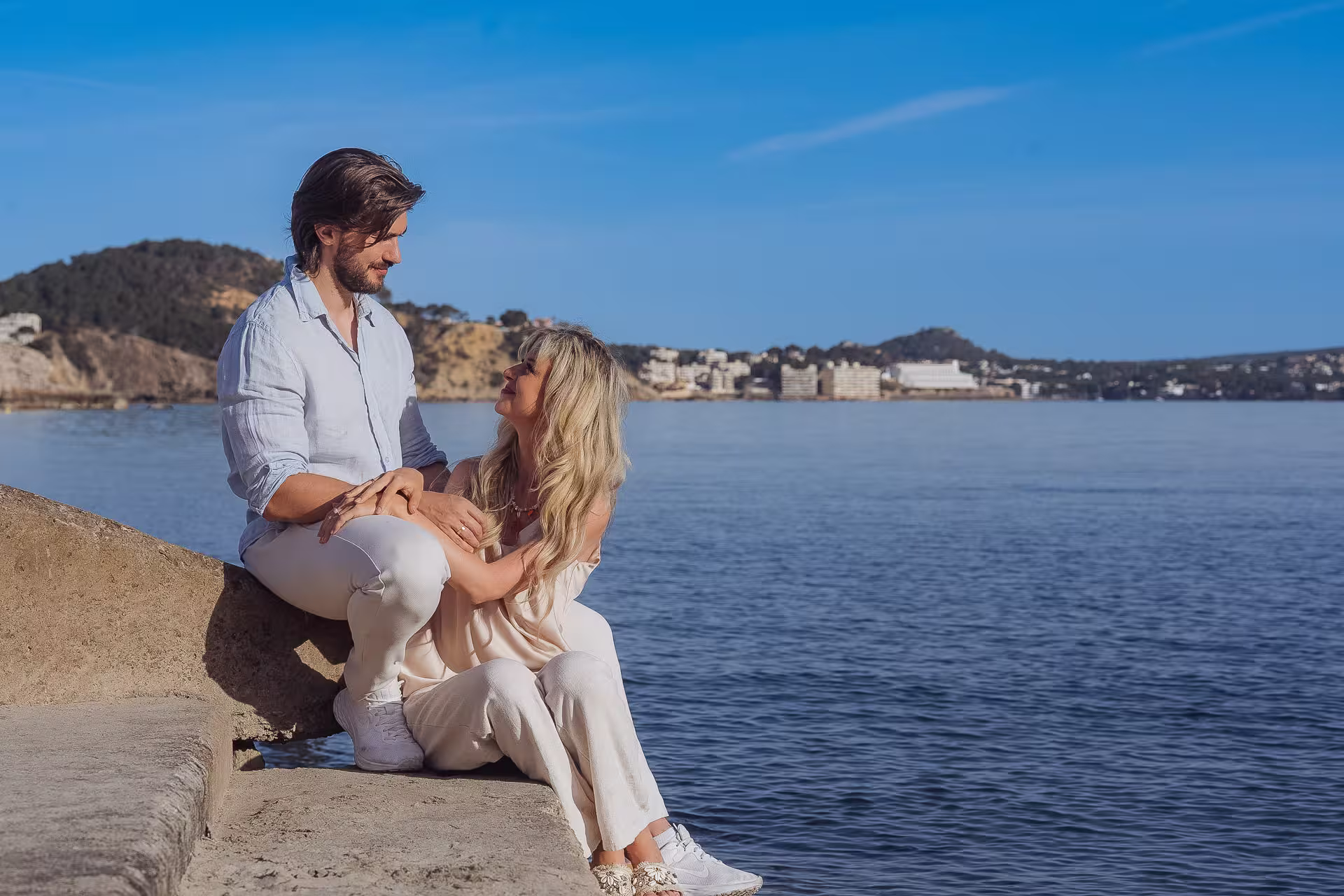 Paar genießt den Strand bei Sonnenlicht, authentische Aufnahme vom Fotograf Mallorca für unvergessliche Urlaubserinnerungen.